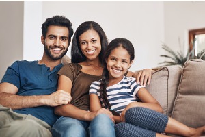 Family sitting on couch smiling